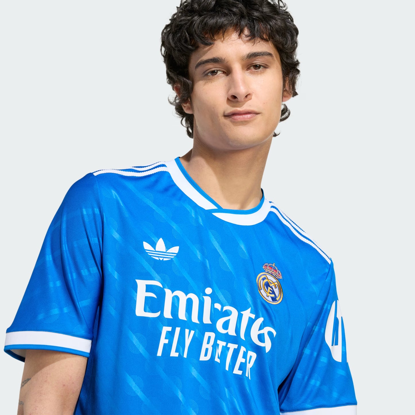 Person wearing a blue sports jersey with visible branding on a plain background