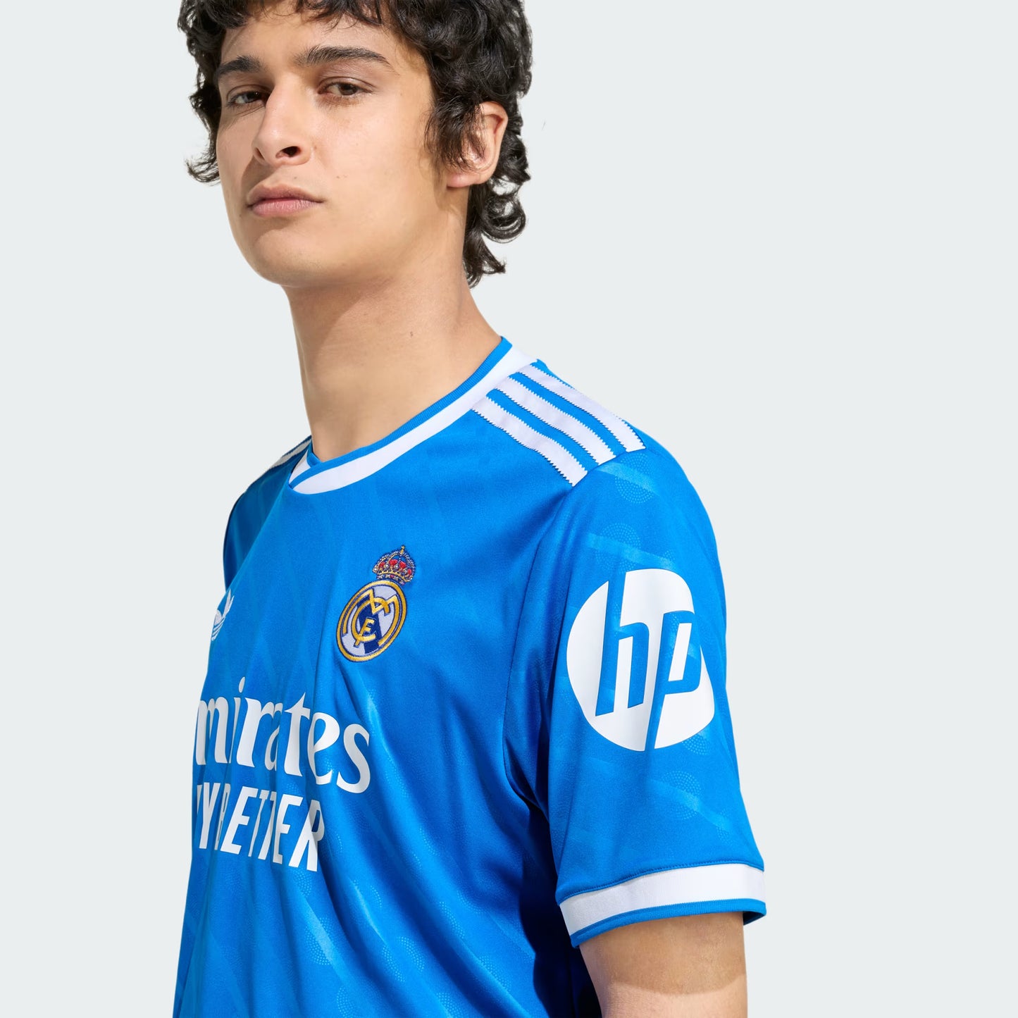 Person wearing a blue sports jersey with visible branding on a white background