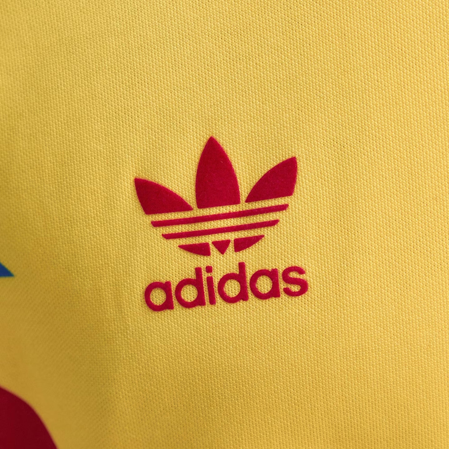 Close-up of Adidas logo on a yellow background