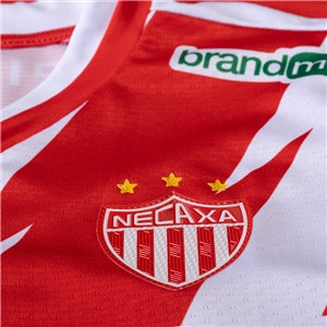 Red and white sports jersey with a logo and 'Necaxa' text, featuring a brand logo.
