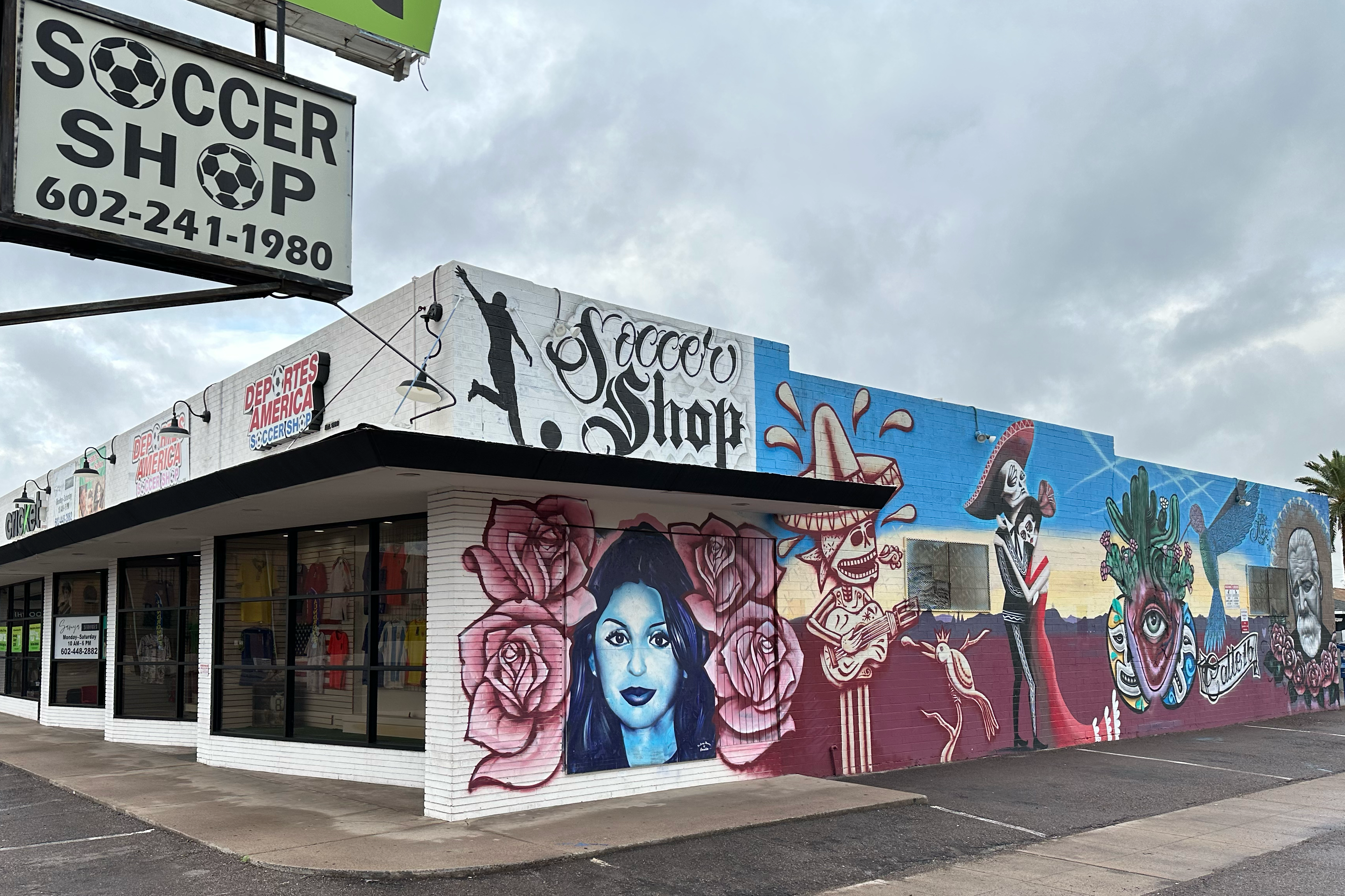 Building with colorful mural on the side, featuring a sign for 'Soccer Shop' above.