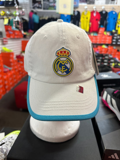 white cap with Real Madrid logo on a mannequin in a store setting