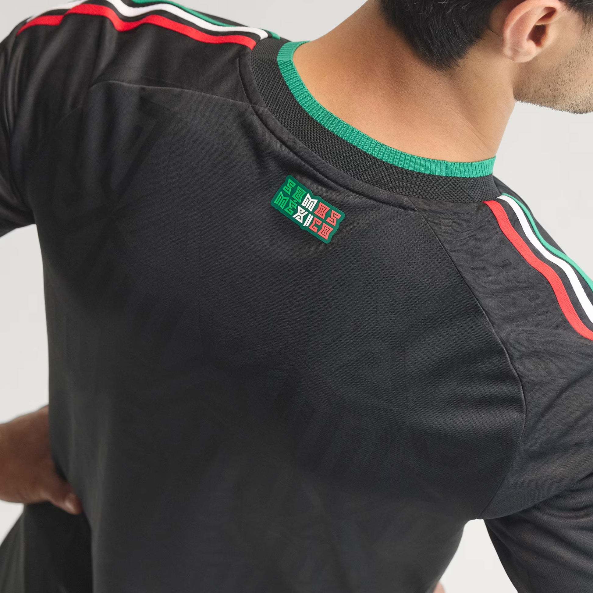 Black sports jersey with green and red accents on a plain background