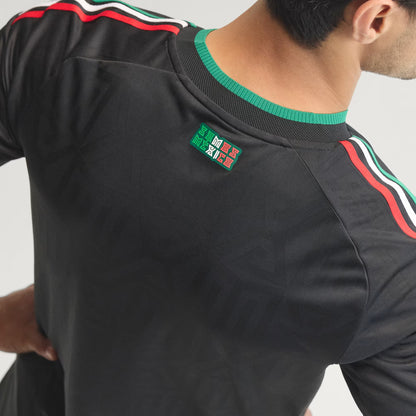 Black sports jersey with green and red accents on a plain background