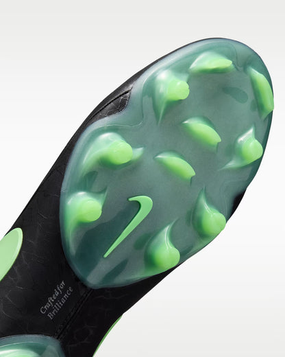 Close-up of the sole of a Nike soccer cleat, showing translucent green molded studs and a green Nike Swoosh on a black textured outsole.