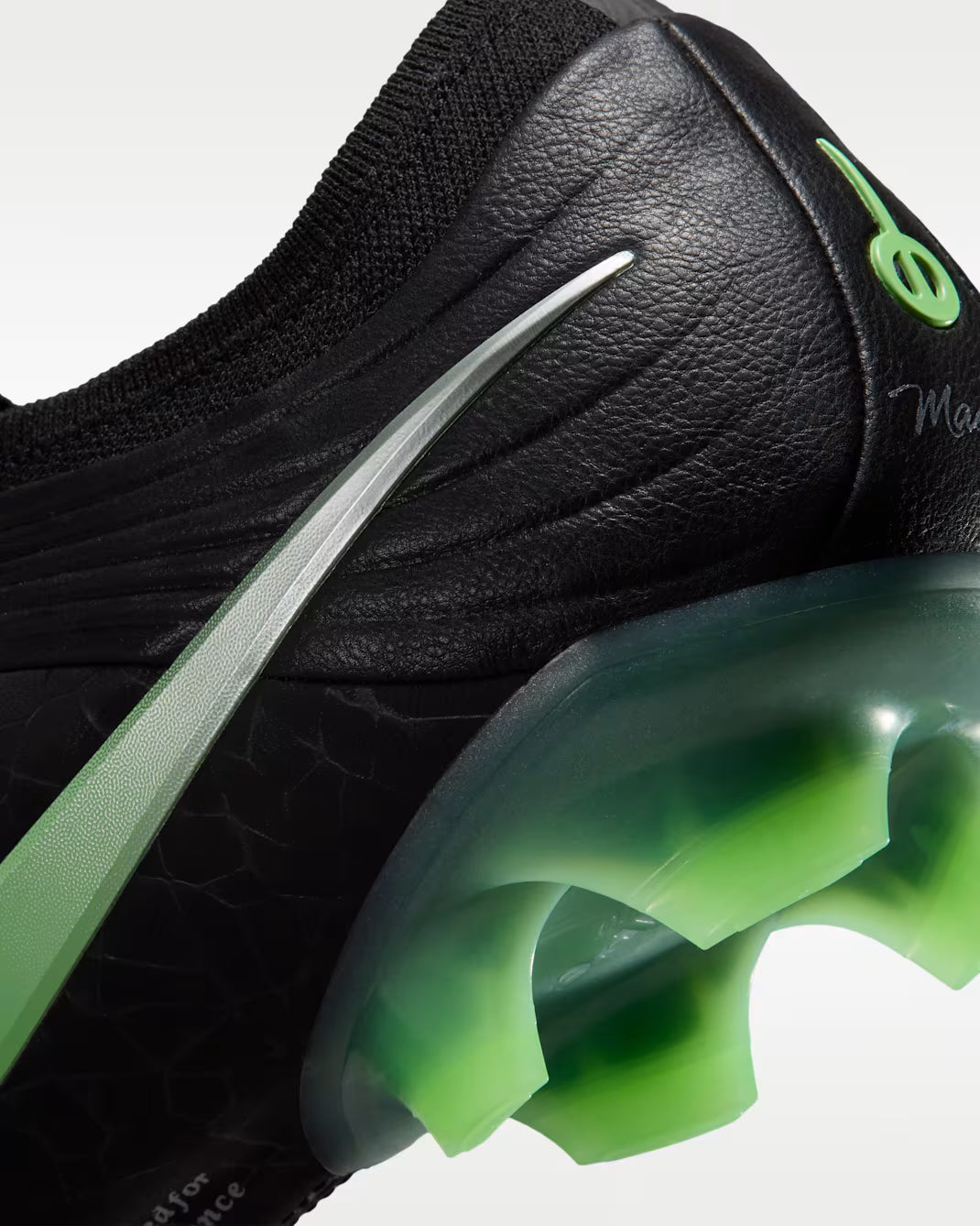 Close-up of a black and green sneaker with a prominent green sole.