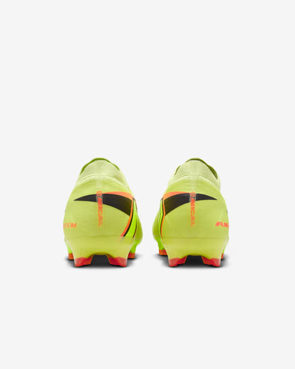 Pair of bright green soccer cleats with black and red accents on a white background