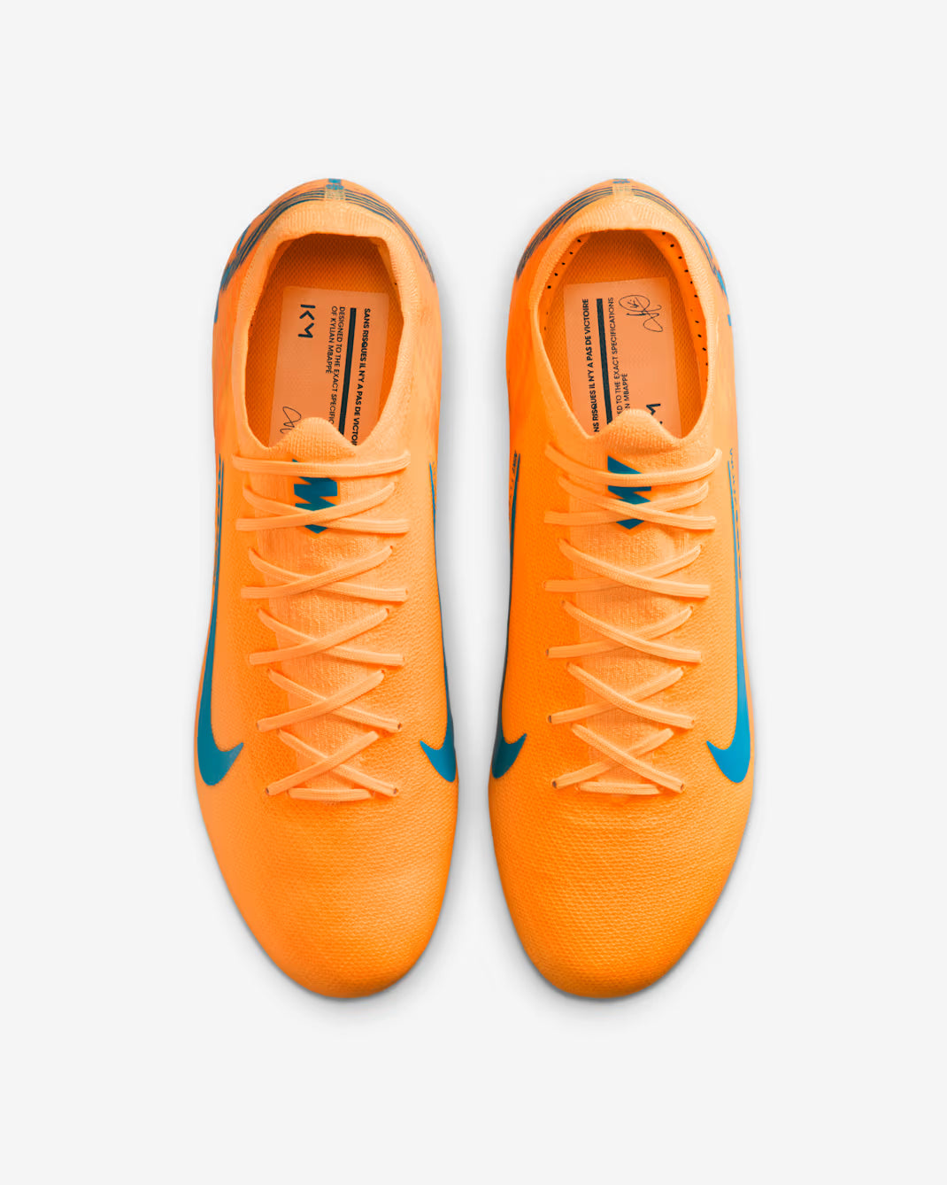 Pair of orange soccer cleats with blue accents on a white background
